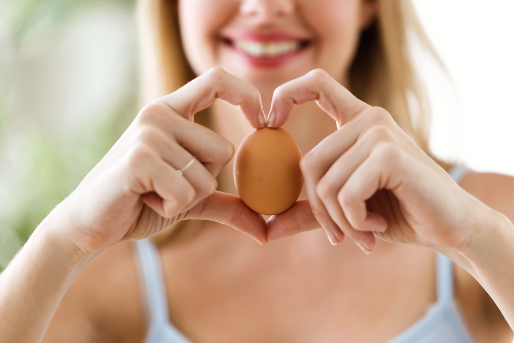 Shot,Of,Beautiful,Young,Woman,Showing,Brown,Chicken,Egg,With